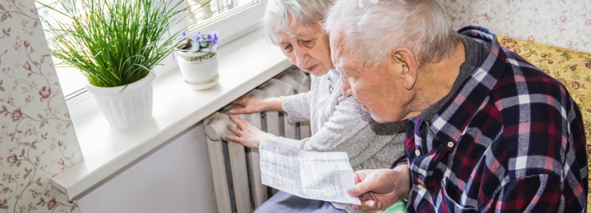 Pensioners looking at bill next to radiator