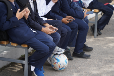Stock image of school children with mobiles (credit Vladimir adobe.stock.com)